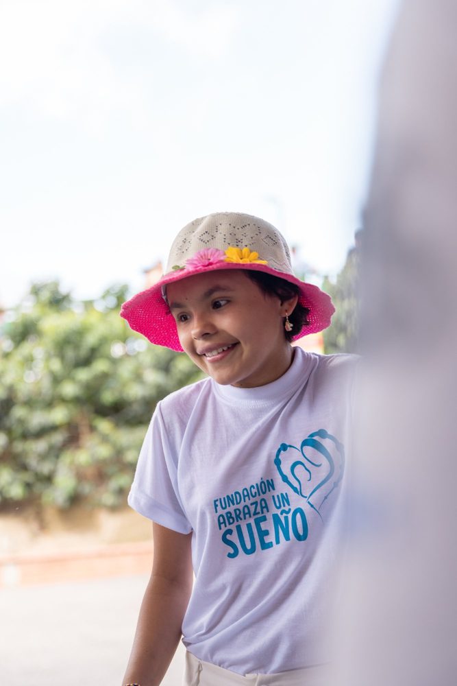 Una niña con sombrero rosado sonríe en el Parque del Café